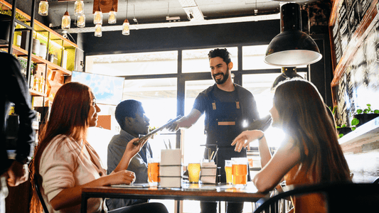 Barista serving organic cold-pressed juices to a diverse group of friends enjoying a casual meet-up at a trendy, rustic Miami café, perfect for content marketing lifestyle imagery.